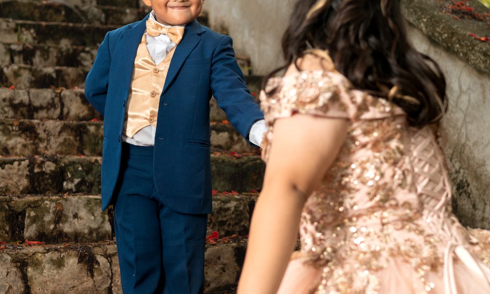 A young boy and girl dressed formally, celebrating a special occasion outdoors. .pexels