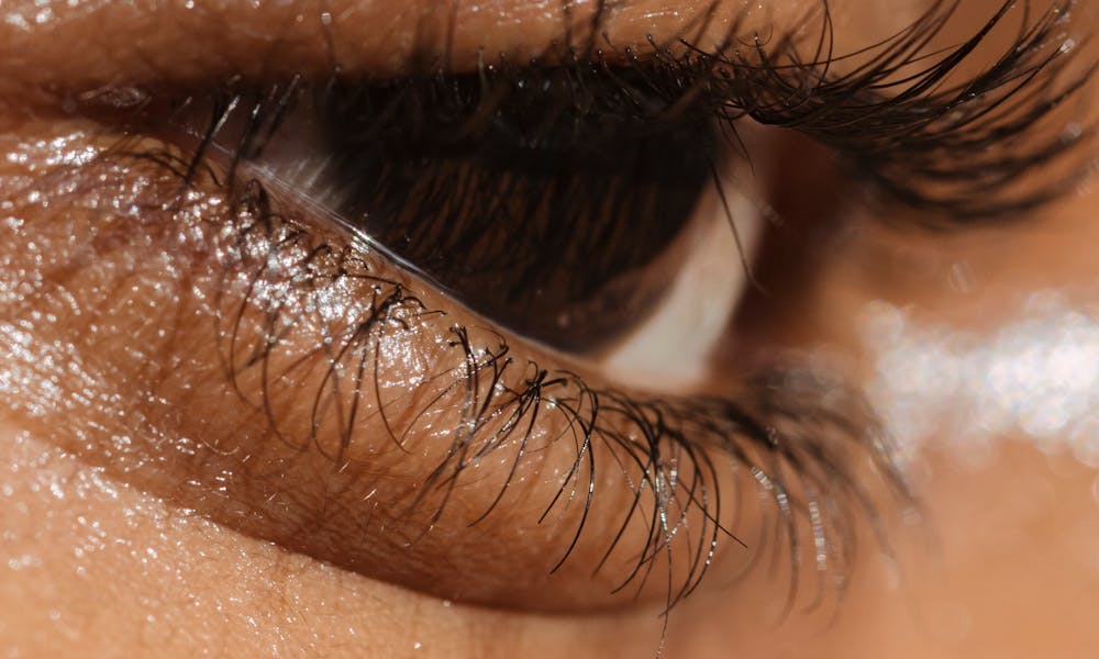 Detailed close-up of a natural eye showcasing eyelashes, lid, and skin texture. .pexels